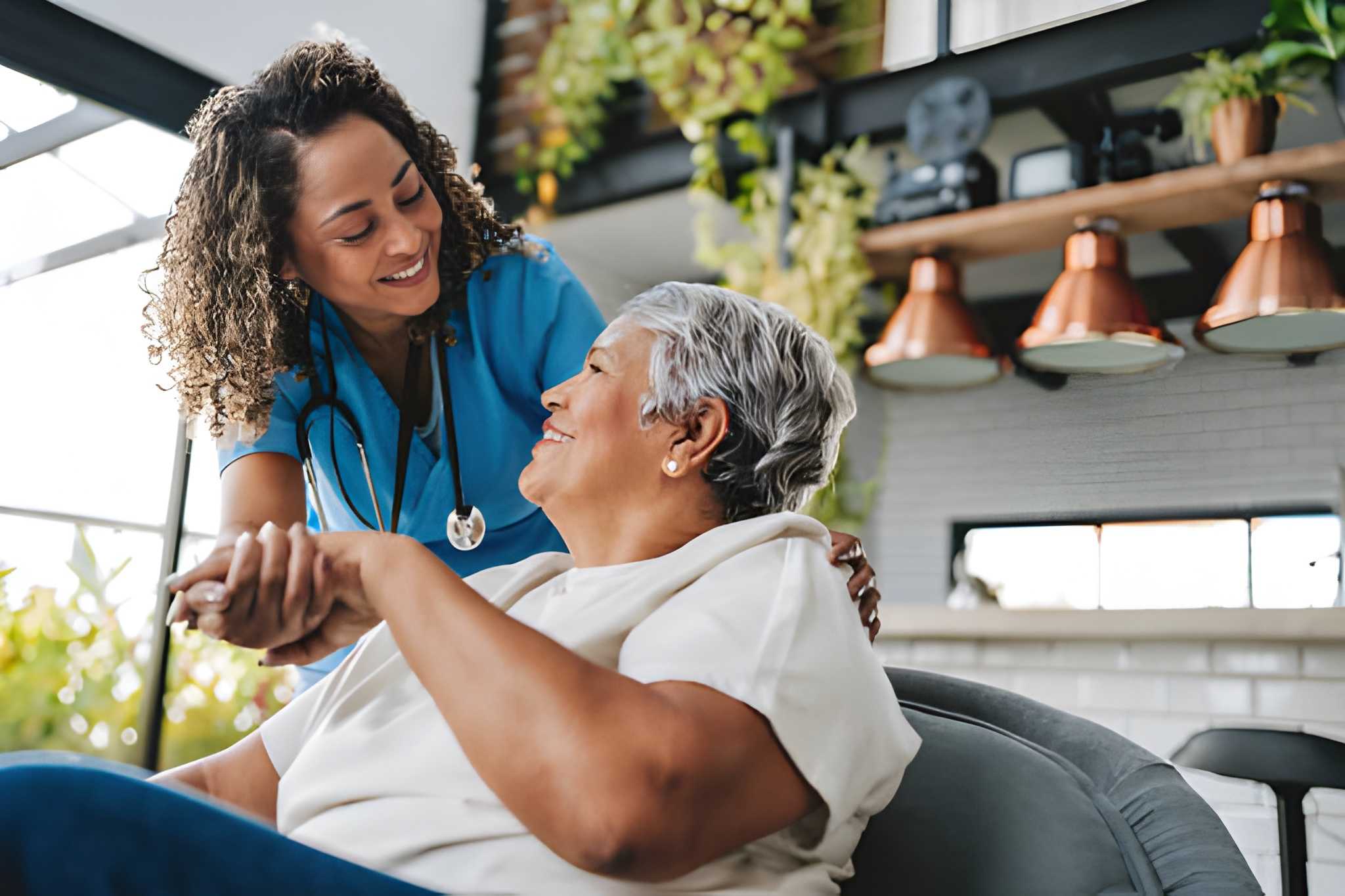 A care coach and family member talking warmly on a living room couch